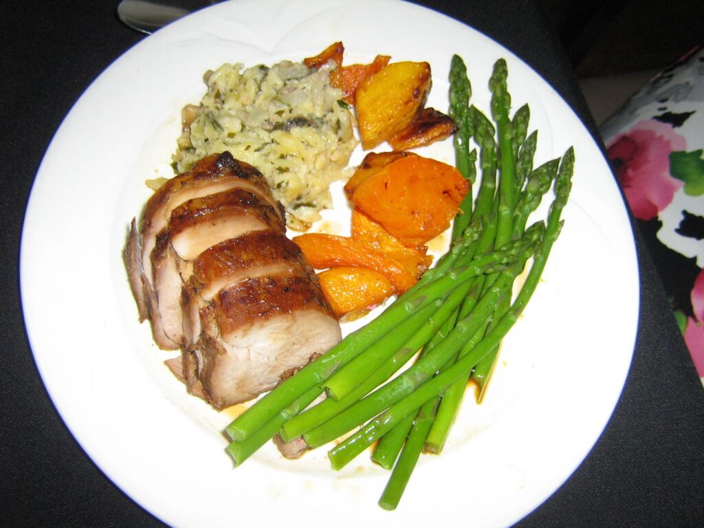 healthy dinner plate, sliced pork, sweet potatoes, asparagus